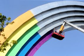 Communards pasting the Arch of Friendship of Peoples with colorful film