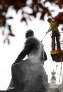 Worker washes monument to Nikolai Lysenko