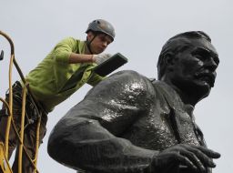 Worker washes monument to Nikolai Lysenko