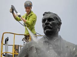 Worker washes monument to Nikolai Lysenko