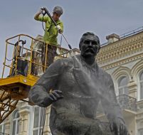 Worker washes monument to Nikolai Lysenko