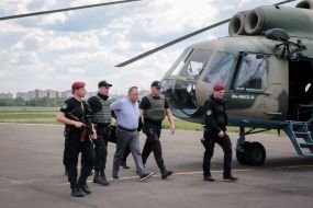 Law enforcement officials accompanying the detained former head of the bus