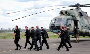 Law enforcement officials accompanying the detained former head of the bus