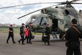 Law enforcement officials accompanying the detained former head of the bus