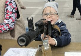The boy takes aim at the machine gun