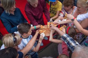 The waiter gives pizza