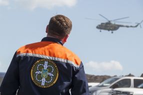 A worker watches a helicopter