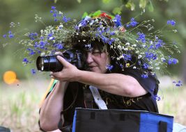 Woman in flower wreath with camera
