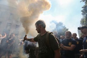 Активист держит зажженный файер 