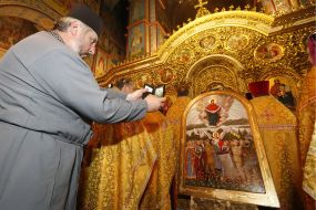 The priest photographs the icon