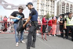 A police officer checks a bag of a passerby