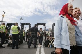 People go through a metal detector frame