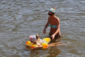 Женщина с ребенком купаются в реке