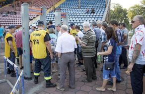 People stand in front of the stadium