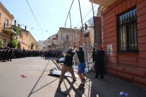 Participants of the rally demolish the building near the house with one wall