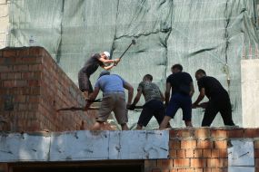 Participants of the rally demolish the building near the house with one wall