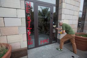 The activist paints the name of the store "Emporium"