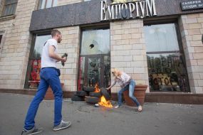 The girl tries to disassemble tires near the store "Emporium"