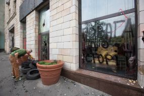 Activist is trying to set fire to the tire near the store "Emporium"