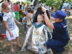 Rescuer GSNS helps the girl wear a protective suit
