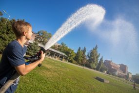 Хлопець тримає пожежний шланг