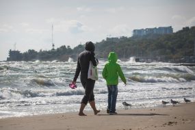 A woman with a child walking along the seashore