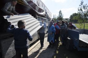 Жителі Павлівки розвантажують покрівельні матеріали 