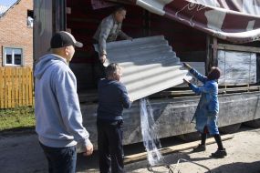 Жителі Павлівки розвантажують покрівельні матеріали 