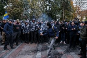 An activist throws a smoke bomb