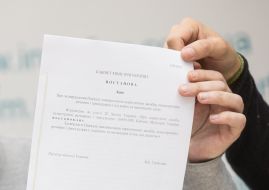 Учасники прес-конференції тримають постанову