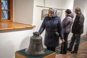 The woman looks at the bell