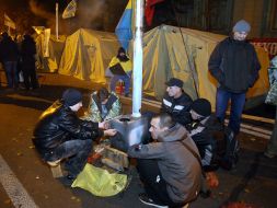 The rally participants warm themselves by the stove