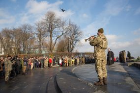 A serviceman plays a pipe