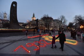 Хрест і цифри, викладені із запалених лампадок