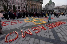 Хрест і цифри, викладені із запалених лампадок