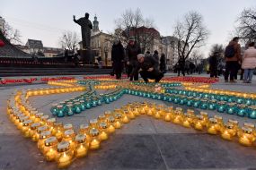 Хрест, викладений із запалених лампадок