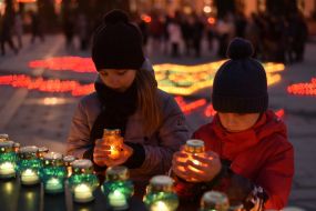 Діти ставлять запалені лампадки