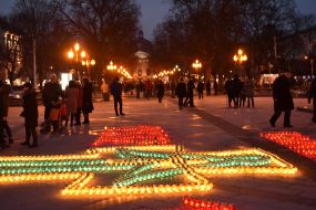 Крест, выложенный из зажженных лампадок