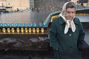 Женщина возле зажженных лампадок