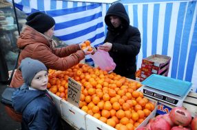 A woman is buying tangerines
