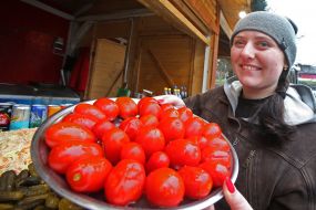 The seller shows salted tomatoes