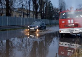 The car is driving through a flooded street