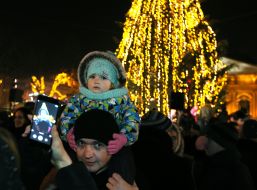 Люди фотографируются на фоне главной новогодней елки