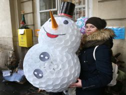 Девушка держит снеговика, сделанного из пластиковых стаканчиков