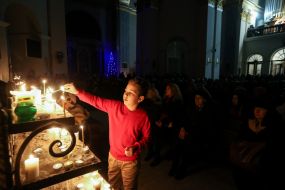 Хлопчик ставить свічку