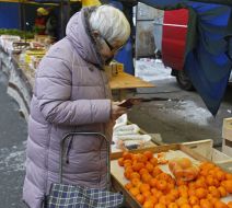 A woman buys tangerines