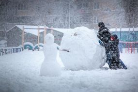 A man and a boy climb a snowman