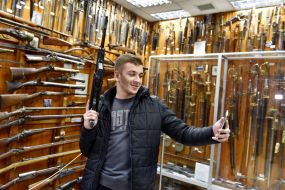 Молодий чоловік робить селфі на тлі експонатів