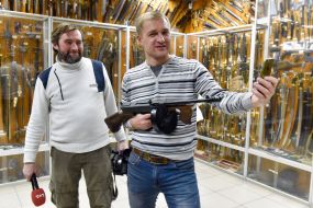 Чоловіки фотографуються на тлі експонатів