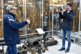 Чоловіки фотографуються на тлі експонатів